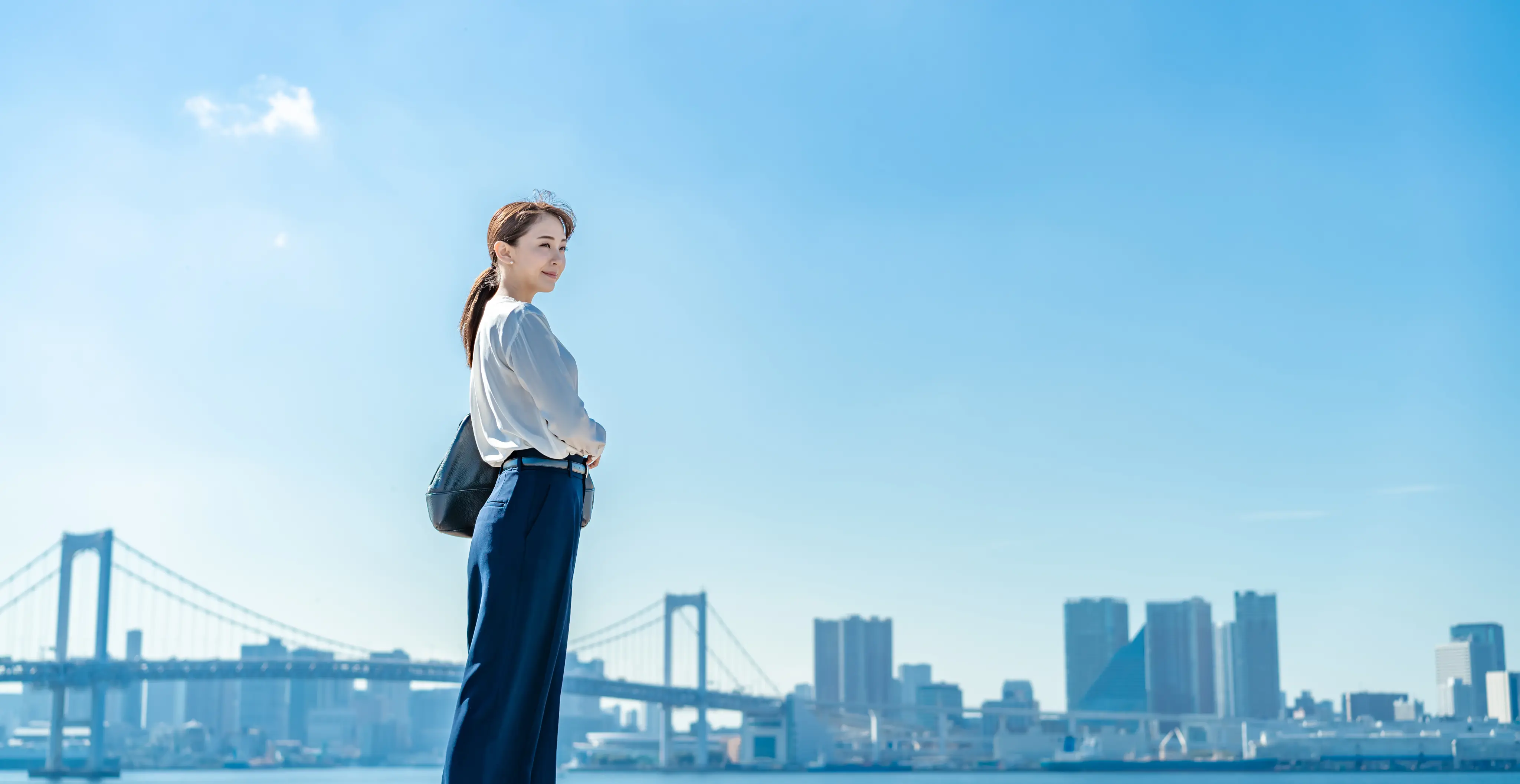橋を望む屋外で立つ女性